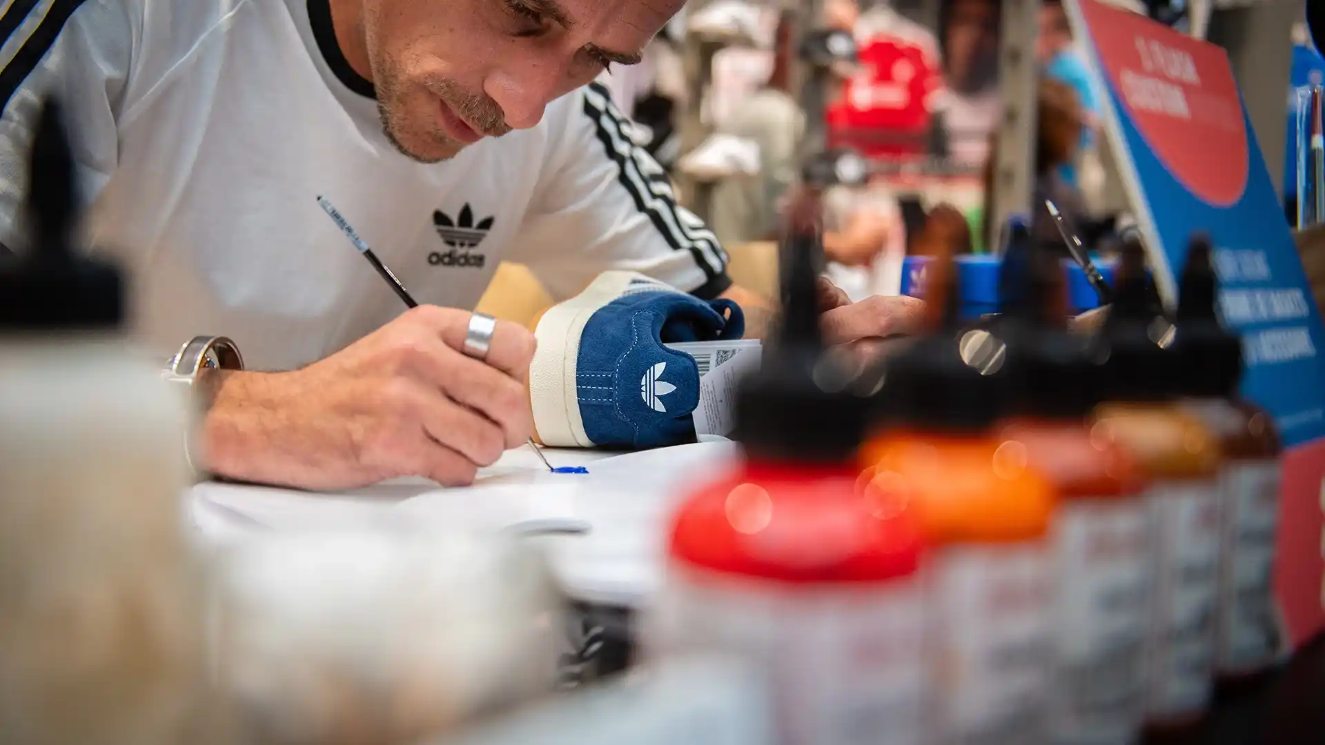 Artiste customisant une paire de sneakers en direct devant des invités